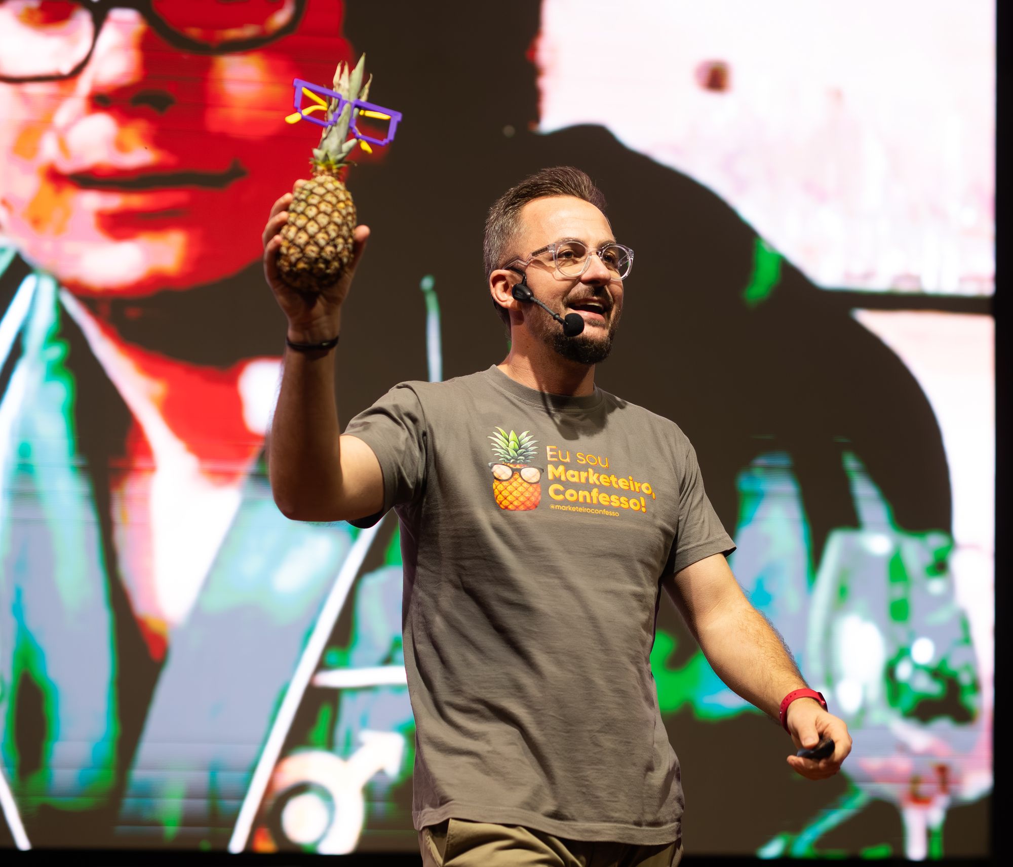 Marcus Tonin no palco segurando um abacaxi de óculos